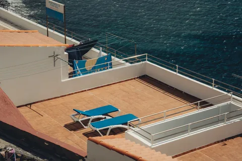 Impermeabilización en Algorta: pide presupuesto. Terraza de un edificio con vistas al mar y tumbonas